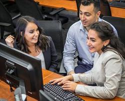 2 female and one male student working as a group