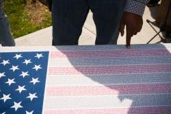 poster of American flag where the strips are made from the names of lives lost on september 11